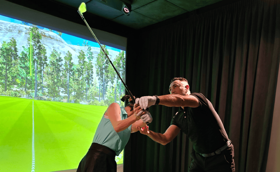 Golfer Receiving Instructor Guidance Indoor Simulator