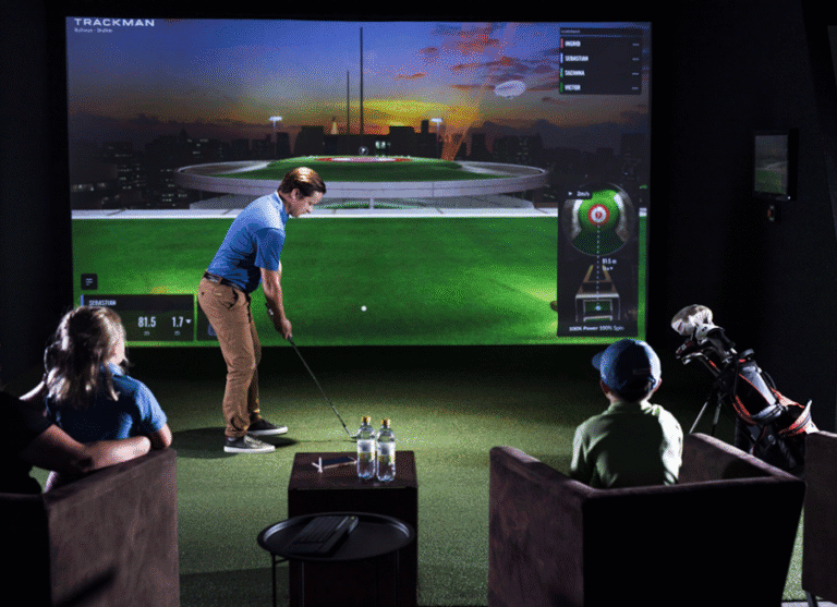 Man Preparing Putt In Simulator With Kids Watching