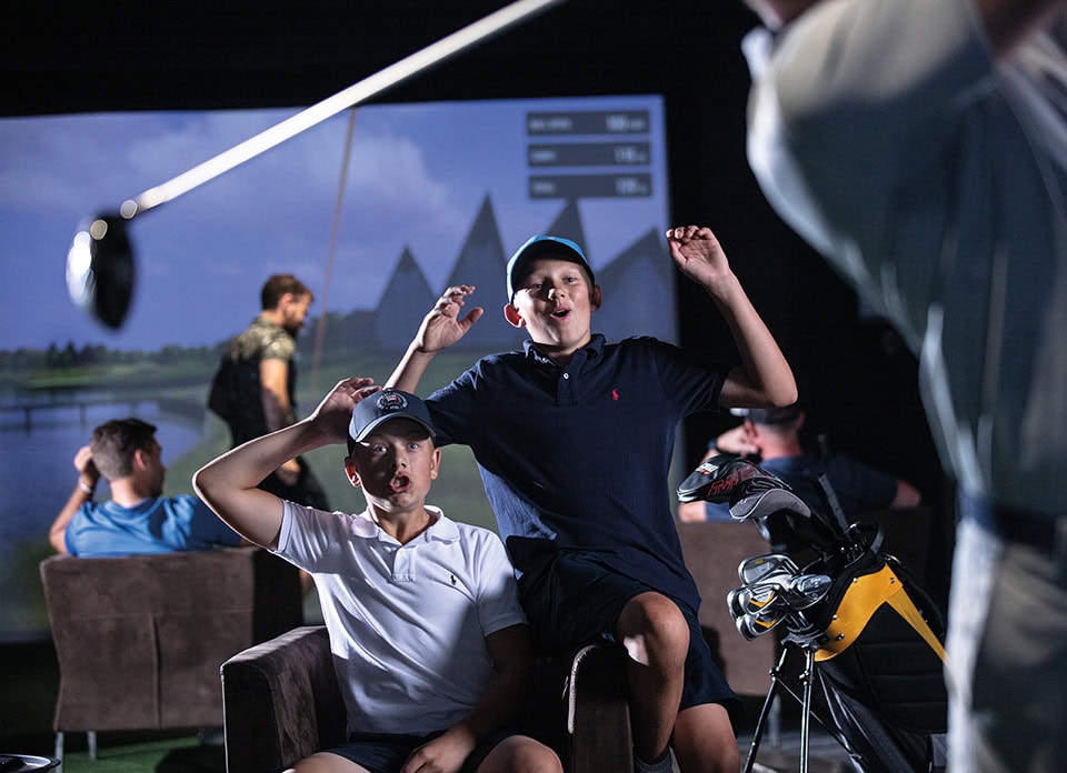 Indoor Golf Simulator Kids Celebrating Shot Golf Lounge